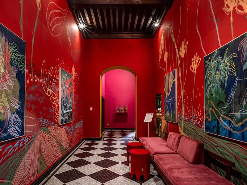 Rita Alaoui mural in a red hallway at El Fenn hotel in Marrakech