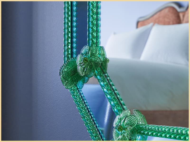 Bed reflected in a green Murano glass mirror inside a Broadwick Soho bedroom.