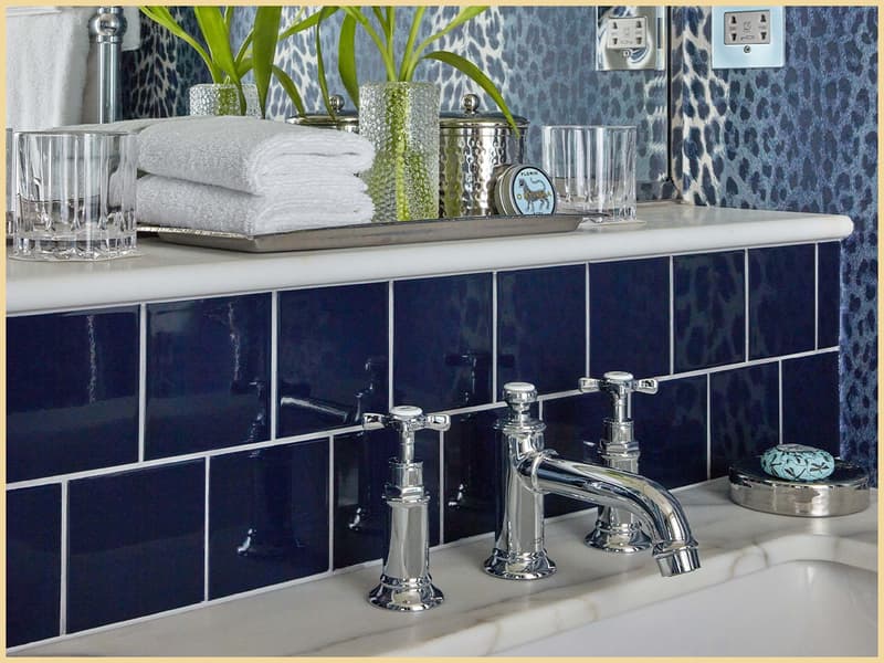 Bedroom bathroom close-up at Broadwick Soho with blue tiles, chrome taps and Ortigia amenities.