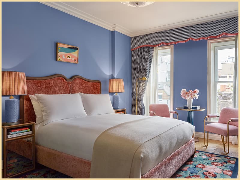 Blue Broadwick Soho bedroom in Soho London with pink bed, floral rug and city-view windows.